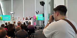 Volontär filmt Redner auf der Bühne