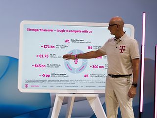 Tim Höttges presenting on stage.